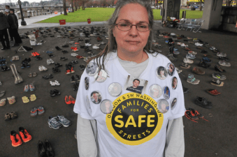 Kristi Finney, who lost her son Dustin when  a truck driver hit him from behind while biking, stands before 421 pairs of shoes symbolizing each person killed in traffic in Oregon so far this year. "The average person is indifferent to this until it happens to them," she told Bike Portland.