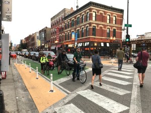 Tan paint and flexible posts have been used to shorten crossing distances, and green bike boxes give cyclists a head start over drivers. Photo: John Greenfield