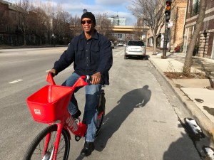 Arron Muhammad, owner of Akhira's Praline, Candy & Coffee House, test rides a Jump bike. Photo: John Greenfield