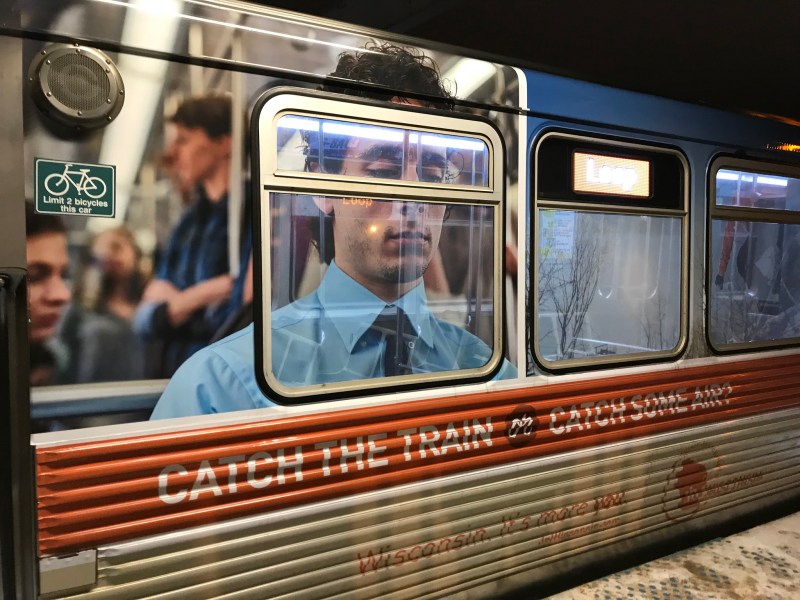A Brown Line car with an ad juxtoposing a depressed CTA rider with a joyful snowboarder with the text "Catch a train or catch air?" Photo: John Greenfield