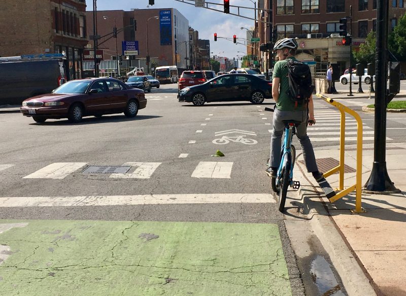 A Divvy bike rider rests their foot on the new Curbee, created by Dero.