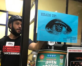 25th Ward aldermanic candidate Hilario Dominguez hangs a poster from the EVERYWHERE campaign in La Casa Del Pueblo taqueria. Photo: Lynda Lopez