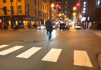 This food delivery cyclist in River North did an "Idaho Stop," stopping at the red light, checking to make sure the intersection was clear, and then proceeding before the light turned green. This move is technically illegal in Chicago, but two-thirds of local cyclists ride this way, according to a DePaul study. Photo: John Greenfield