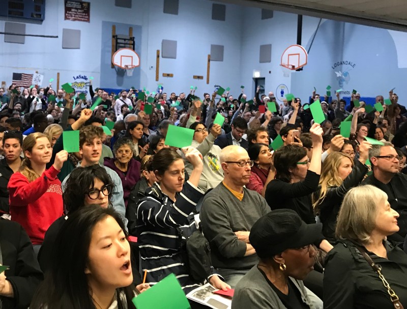 Residents show support for a speaker at last night's hearing by displaying green cards. Photo: John Greenfield