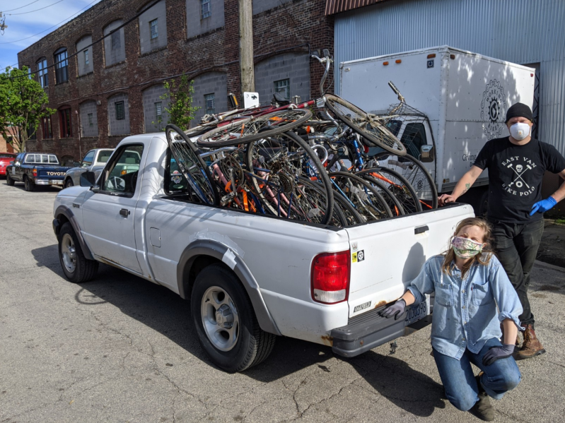 Working Bikes Cooperative staffer Devon Snyder (kneeling) helping load in bikes donated from Working Bikes to Bikes N' Roses with Mark Frens from Bikes N' Roses. Photo: Trevor Clarke
