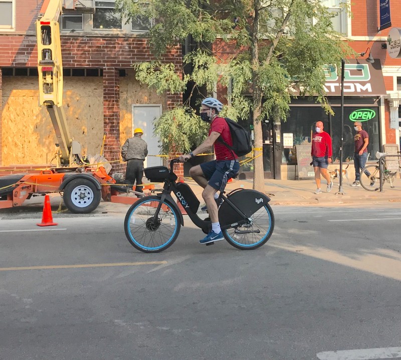 Sign of the times: A masked rider on one of the new e-Divvies. Photo: John Greenfield