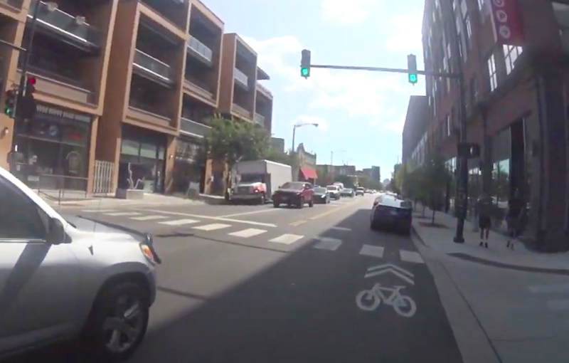 Still from Kyle Davison's video showing drivers improperly parked in the curb lane, where cyclists are supposed to be riding, due to the lack of "No Parking" signs.