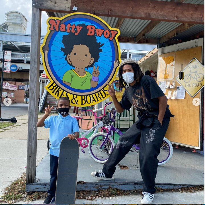 Kahari Blackburn standing with a young person outside Natty Bwoy Bikes & Boards in Boxville. Photo: Natty Bwoy