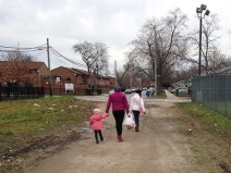 Altgeld Gardens residents returning from Rosebud Farm Stand on the dirt road next to the market a few years ago. The store, the only source for fresh groceries in the neighborhood, has since closed. Photo: John Greenfield