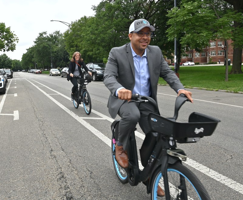 CDOT commissioner Gia Biagi and 24th Ward alderman Michael Scott ride electric Divvy bikes on Douglas Boulevard in North Lawndale during the ribbon-cutting event. Photo: CDOT
