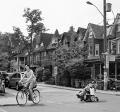 A person biking and a person using a wheelchair in Toronto's Kensington Market. Photo: Eric Parker