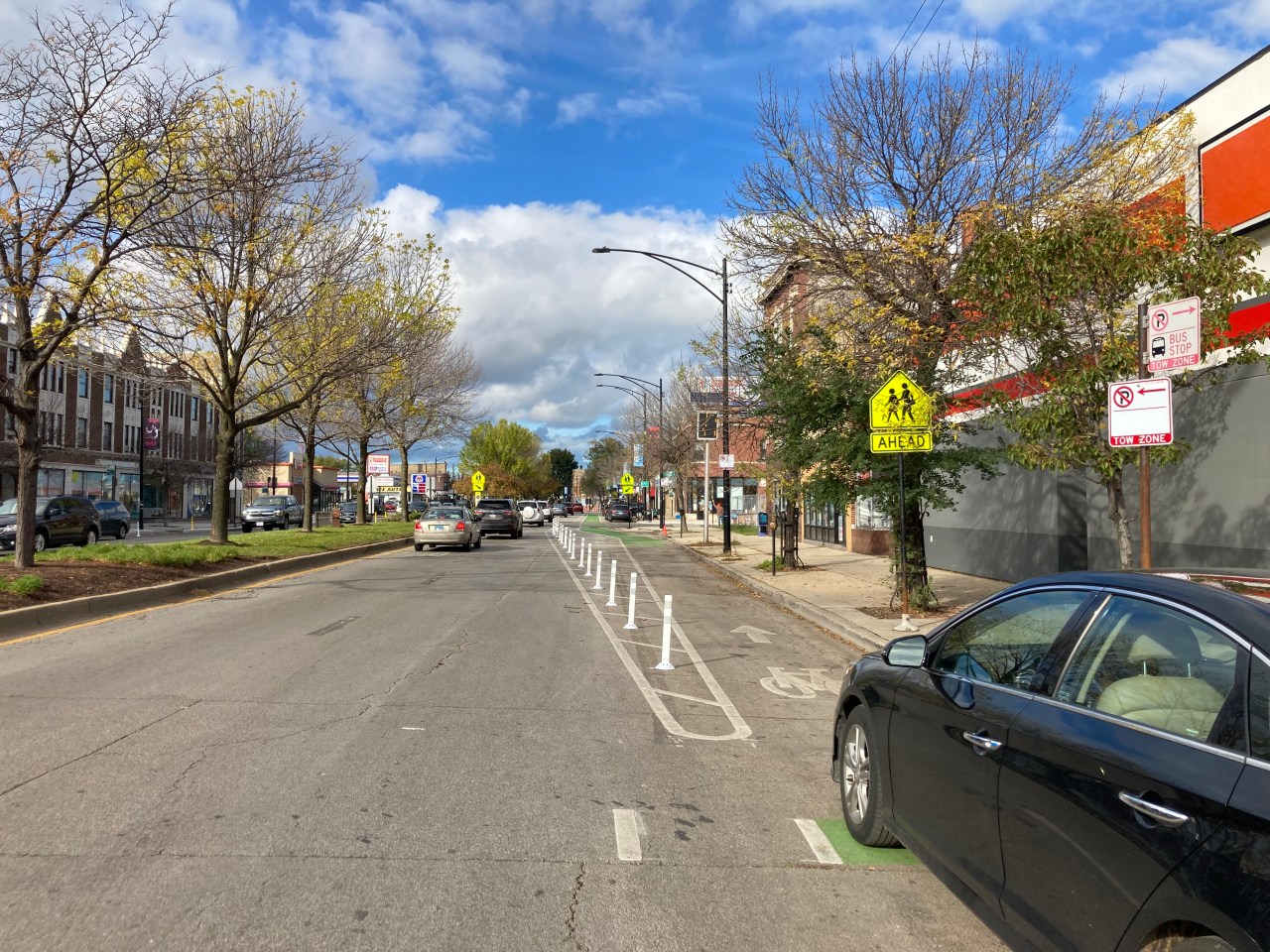 Posts keeping motorists from driving in the bike lane: good. Car parked in the bike lane: bad. Photo: John Greenfield