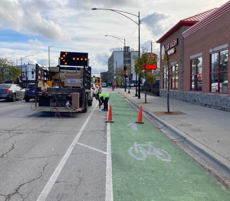 A worker bolts down a bollard on Clark Street. Photo: John Greenfield