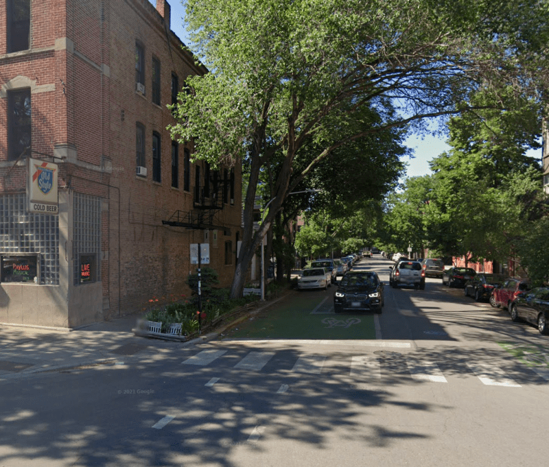 Green bike box pavement markings at Division and Wood, part of the Wood Street Neighborhood Greenway. 1st Ward residents voted to convert the corridor to a one-way northbound street to make room for a two-way protected bike lane. Image: Google Maps