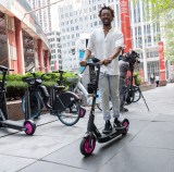 Riding one of the new Divvy scooters at the Thompson Center ribbon-cutting. Note the silver triangle at the front of the scooter for securing it in a docking station. Photo: CDOT