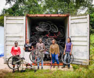Las mujeres del taller Bwindi Women Bicycle Enterprise Shop (BWBES) en frente de un contenedor de bicicletas. Foto: BWBES