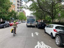 A bike rider is forced to ride in the mixed-traffic lane on Leland, near where an illegally parked ComEd truck contributed to the death or Lily Shambrook, 3, last week, because a Century Springs water delivery truck is parked in a bike lane. Photo: John Greenfield