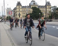 Cycling on a raised bike lane in Copenhagen. In countries with lots of biking, almost no one wears a helmet, and yet the bike fatality rate is much lower than in nations like the U.S. where helmet use is common. Why? Photo: John Greenfield