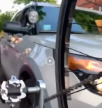 Still from the video showing the unmarked police SUV after the driver struck the teen who was filming from his bike. The wheel and pedal of his bike is visible in the frame. Image: Facebook