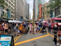 A young girl takes a swing at the High Striker carnival game. Photo: Sharon Hoyer